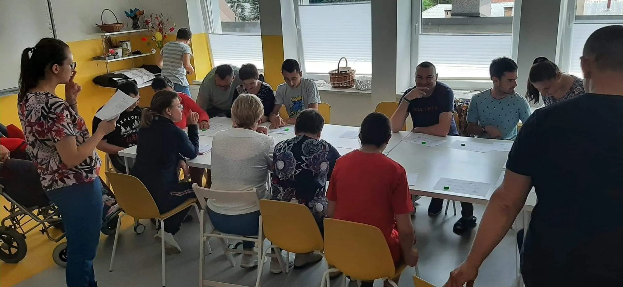 Grupa podopiecznych i opiekunów podczas zajęć warsztatowych